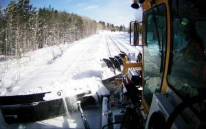 A KSF 940 Snow Fighter removing snow from railway tracks in forest.